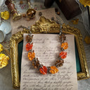 The Lisner Lucite necklace styled with fresh citrus fruits to emphasize its vibrant, joyful color palette and its identity as a piece of wearable sunshine.