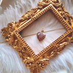 The reverse side of the upcycled Strawberry Quartz charm, showcasing the clean bezel setting and the beautiful, natural red inclusions visible through the stone.