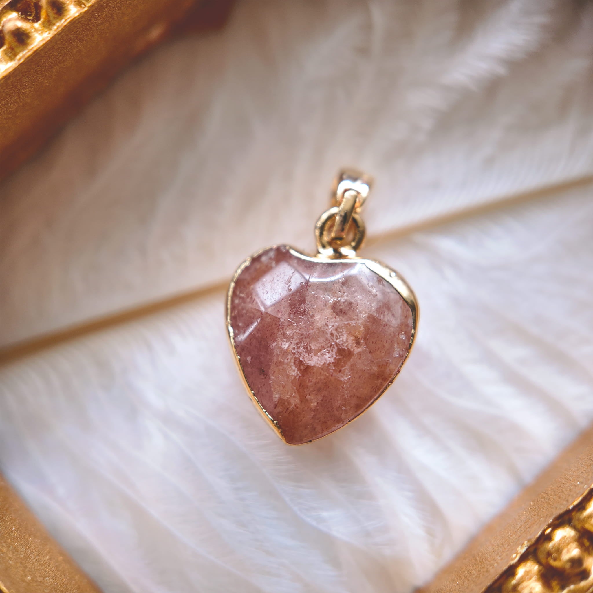 The reverse side of the upcycled Strawberry Quartz charm, showcasing the clean bezel setting and the beautiful, natural red inclusions visible through the stone.
