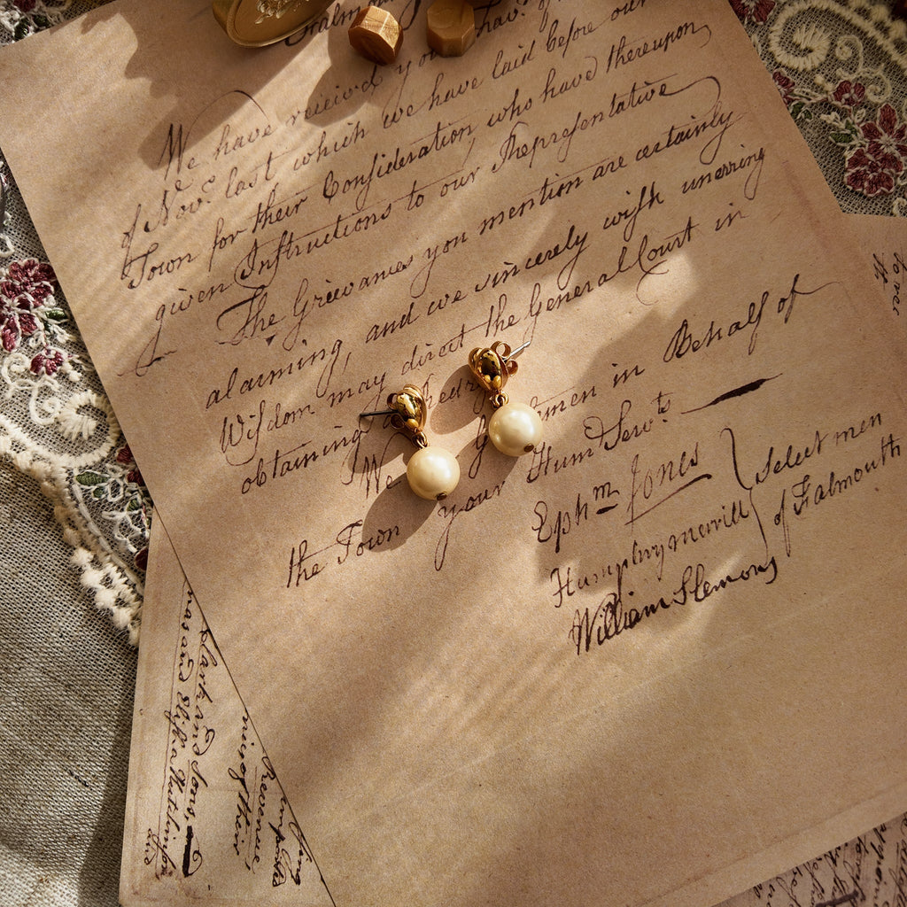 The Avon "Daily Dose of Darling" earrings styled on a cozy sweater to emphasize their versatile, "everyday classic" aesthetic and their charming, simple beauty.