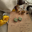 The "Enigmatic Heiress" earrings styled next to oversized sunglasses to evoke an "Italian Summer" and "White Lotus" aesthetic, a symbol of mysterious glamour.