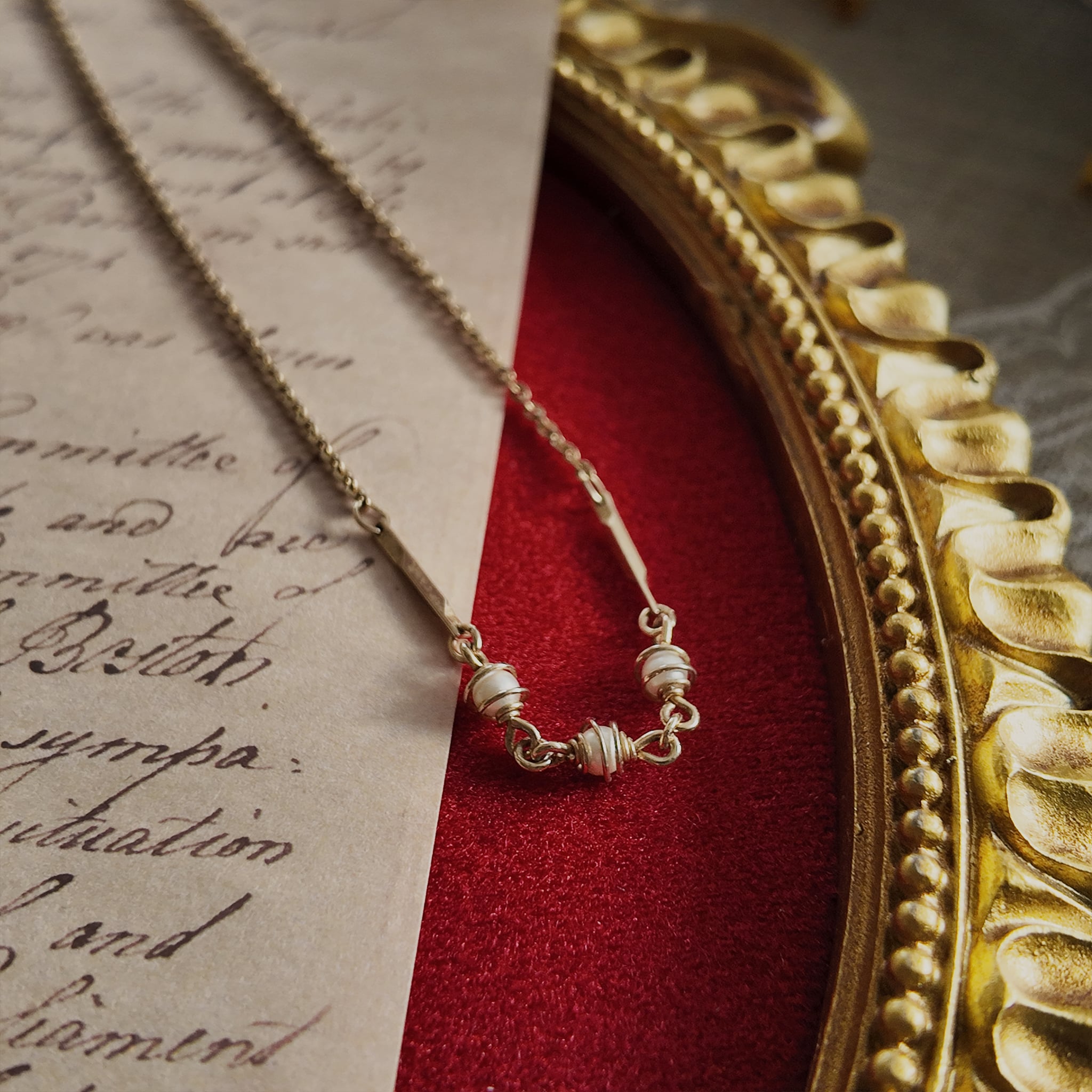 A macro shot detailing the weathered, muted patina of the bronze-tone metal as it wraps around the luminous pearls, embodying a "raw beauty" aesthetic.