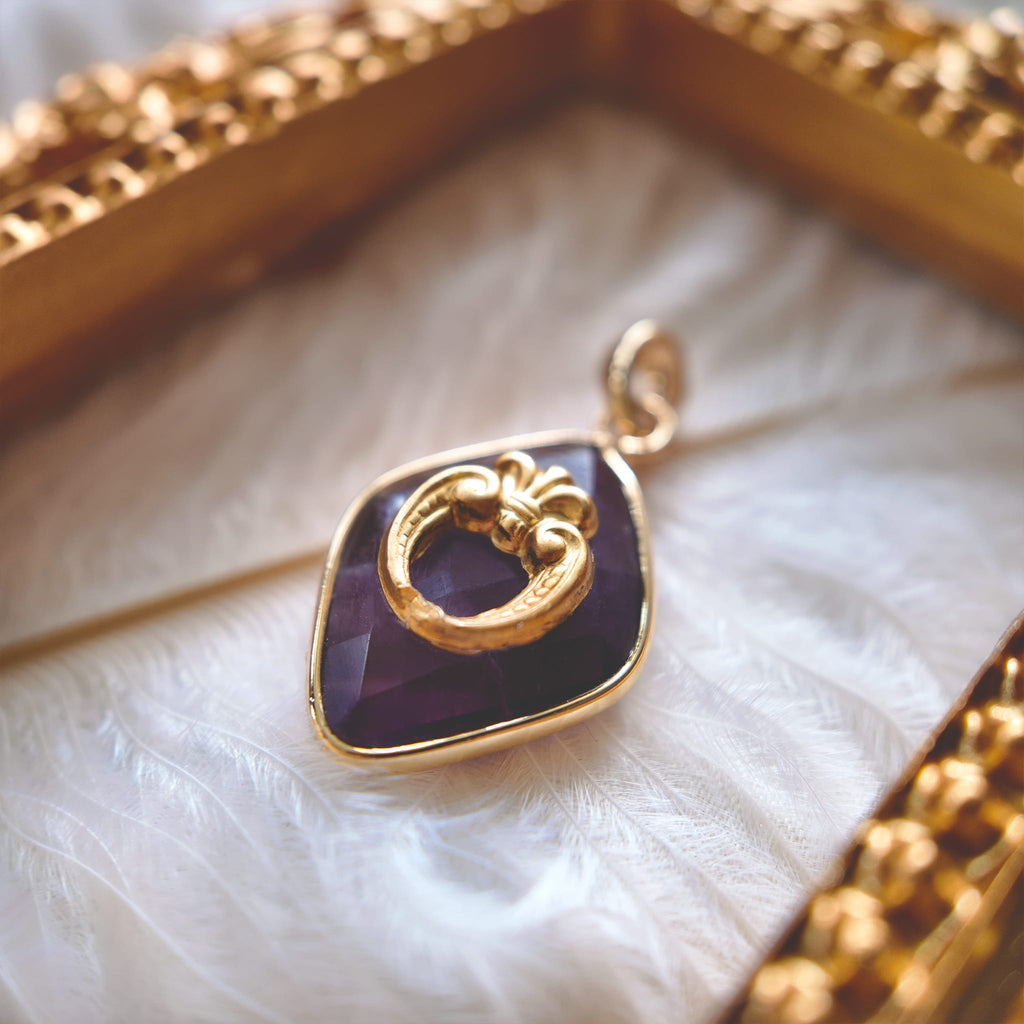 A macro shot detailing the sharp, floral and sword-like motifs within the vintage brass filigree, and the rich, royal purple color of the faceted Amethyst.