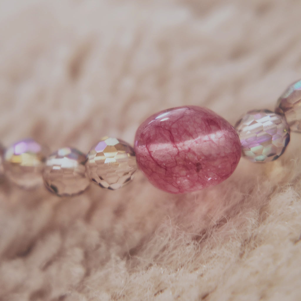 A macro shot detailing the precise machine-cutting of the faceted Czech glass and the natural, organic texture of the amethyst and pink agate crystal accents.
