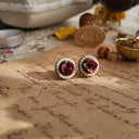 The "Gardener's Daughter" earrings styled on a bed of moss to emphasize their "earthy charm" and their identity as a "wearable piece of the earth."