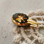 A macro shot detailing the crisp intaglio carving and the intact gold leaf filling within the vintage West Germany glass, a sign of its excellent condition.