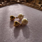 A macro shot honestly detailing the fine, hairline scratches on the gold-tone surface, a sign of this "well-loved" pair of vintage Avon earrings, sold as-is.