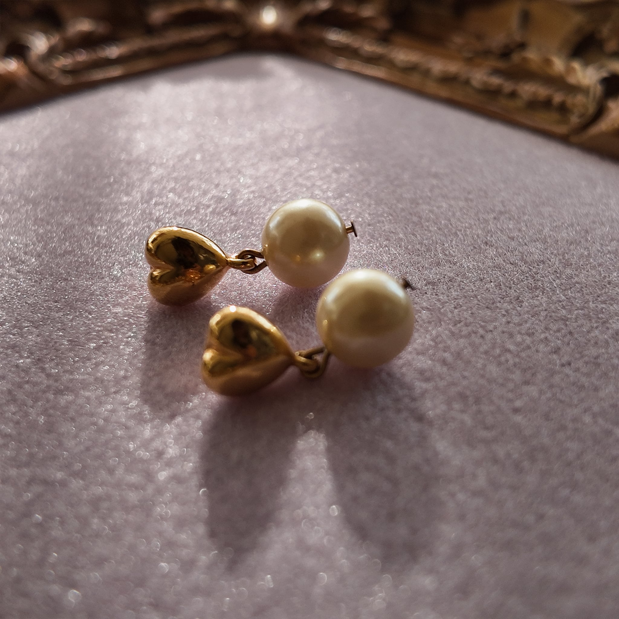 A macro shot honestly detailing the fine, hairline scratches on the gold-tone surface, a sign of this "well-loved" pair of vintage Avon earrings, sold as-is.