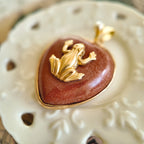 Side profile of the heart-shaped Goldstone pendant, showing its form and the gold-plated bezel.