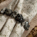 A substantial Sorrelli crystal bracelet worn on a wrist, showcasing its impressive size and intellectual style, perfect for a Dark Academia or Gothic look.