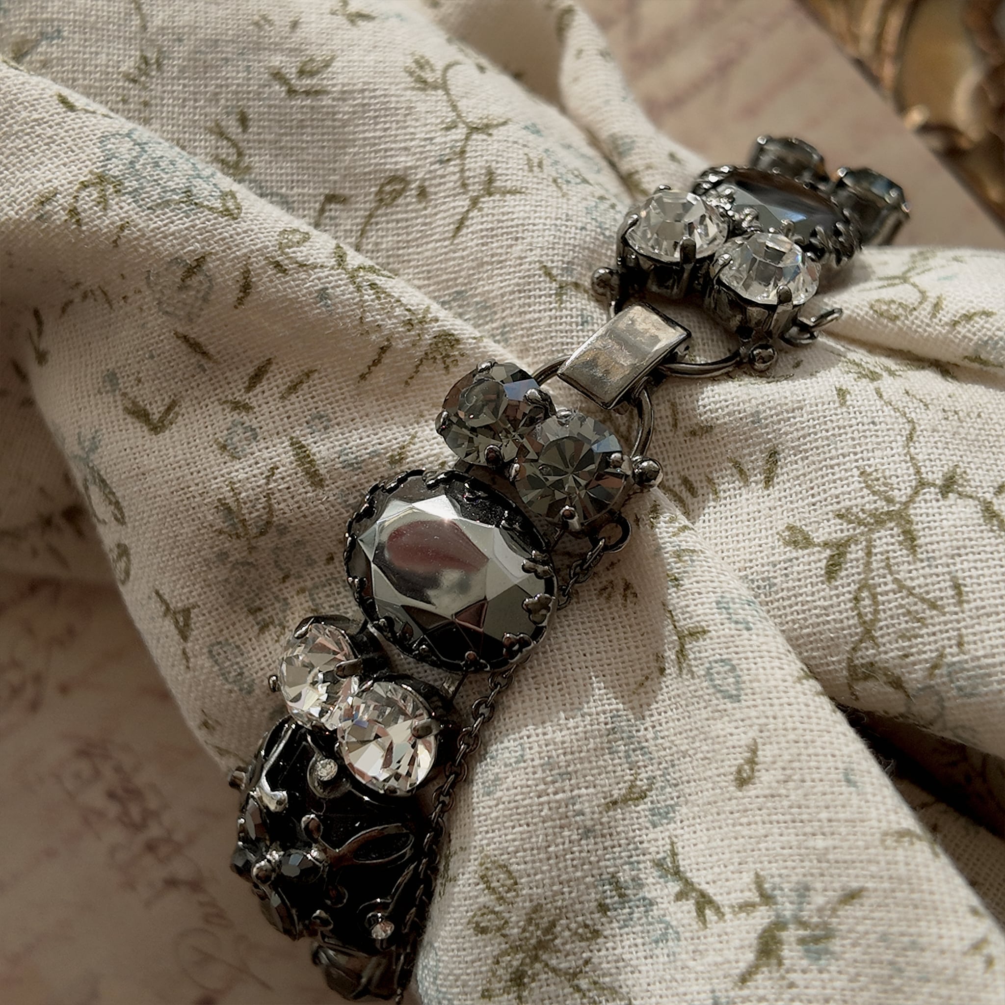 A substantial Sorrelli crystal bracelet worn on a wrist, showcasing its impressive size and intellectual style, perfect for a Dark Academia or Gothic look.