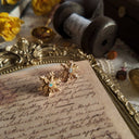 A macro shot detailing the incredible, opal-like fire and the full spectrum of iridescent colors flashing within the central crystal of the vintage Avon earrings.