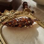 An angled view of the Juliana brooch, highlighting the masterful arrangement of navette, round, and rare keystone-cut rhinestones in a dimensional design.