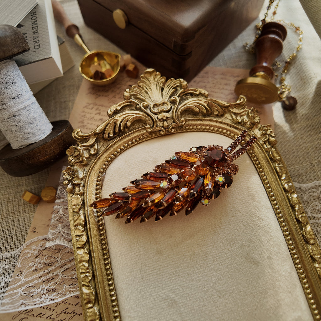 The "Secret Magician," a large, confirmed vintage Juliana (D&E) statement brooch, featuring a stunning collage of amber, topaz, and Aurora Borealis crystals.