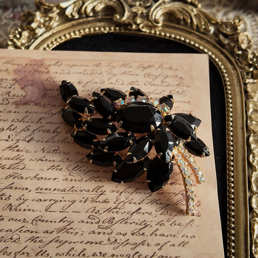 The "Prima Ballerina," a large, dramatic vintage statement brooch attributed to Juliana (DeLizza & Elster), with sweeping black glass leaves and fiery Aurora Borealis crystals.
