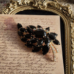 The "Prima Ballerina," a large, dramatic vintage statement brooch attributed to Juliana (DeLizza & Elster), with sweeping black glass leaves and fiery Aurora Borealis crystals.