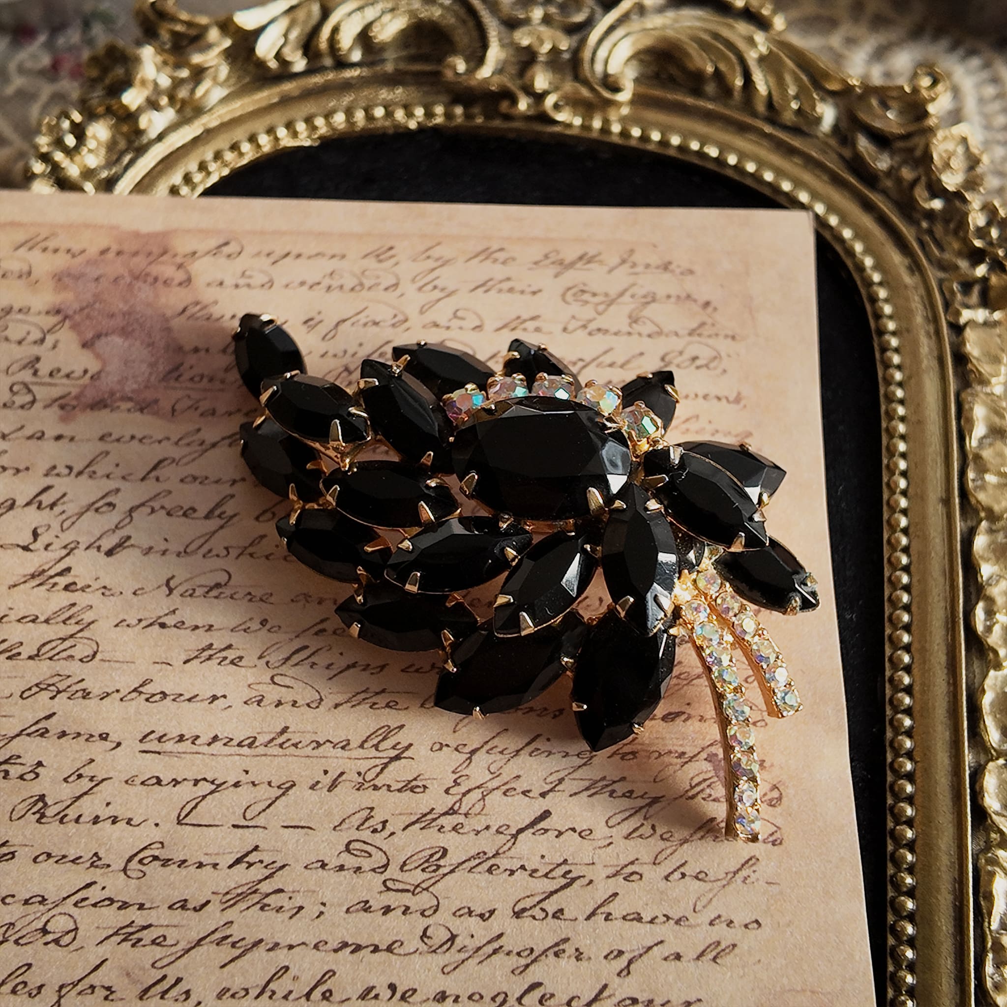 The "Prima Ballerina," a large, dramatic vintage statement brooch attributed to Juliana (DeLizza & Elster), with sweeping black glass leaves and fiery Aurora Borealis crystals.