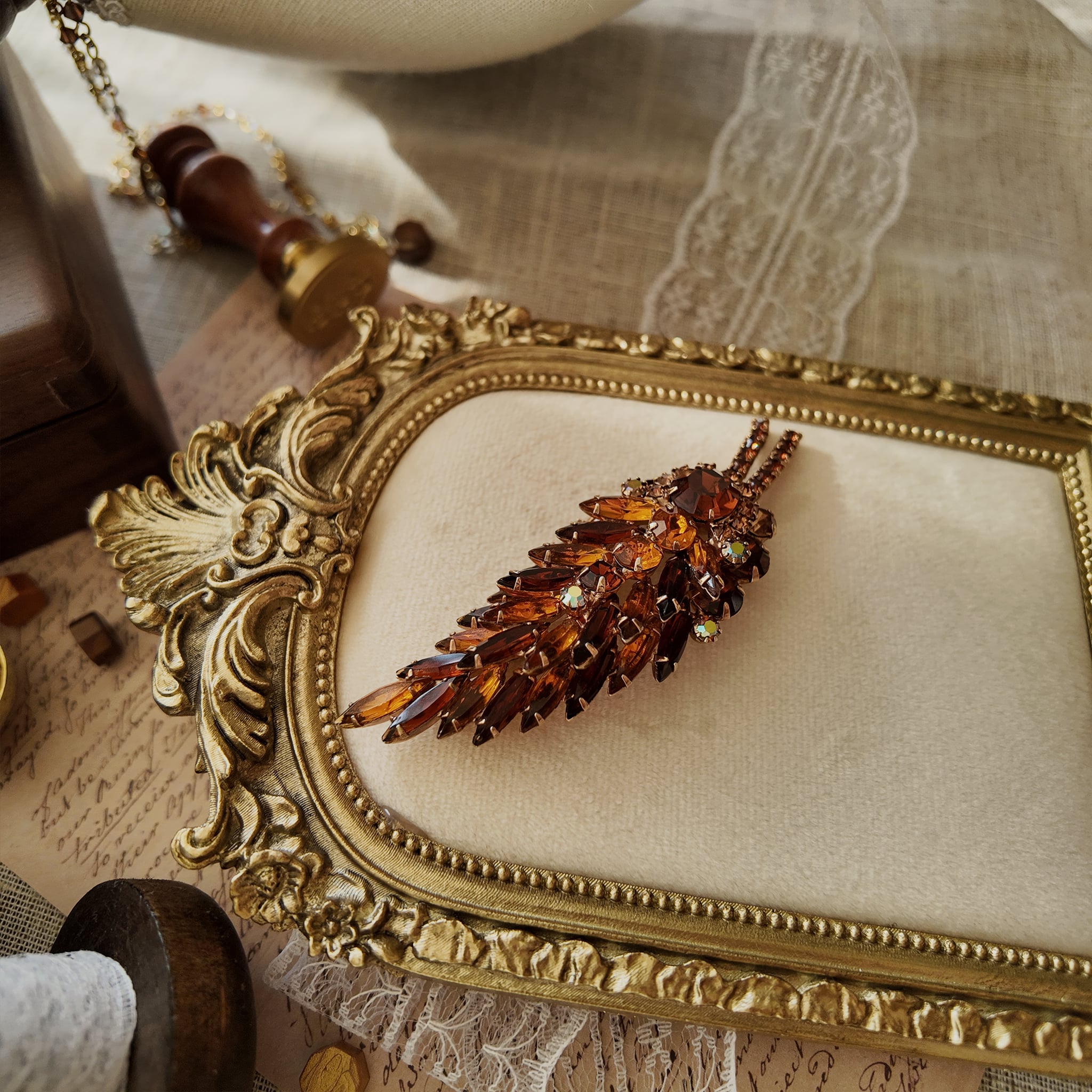 The Juliana "Secret Magician" brooch styled in a warm, sunset-like setting to emphasize its "riot of color" and its identity as a piece of wearable art.