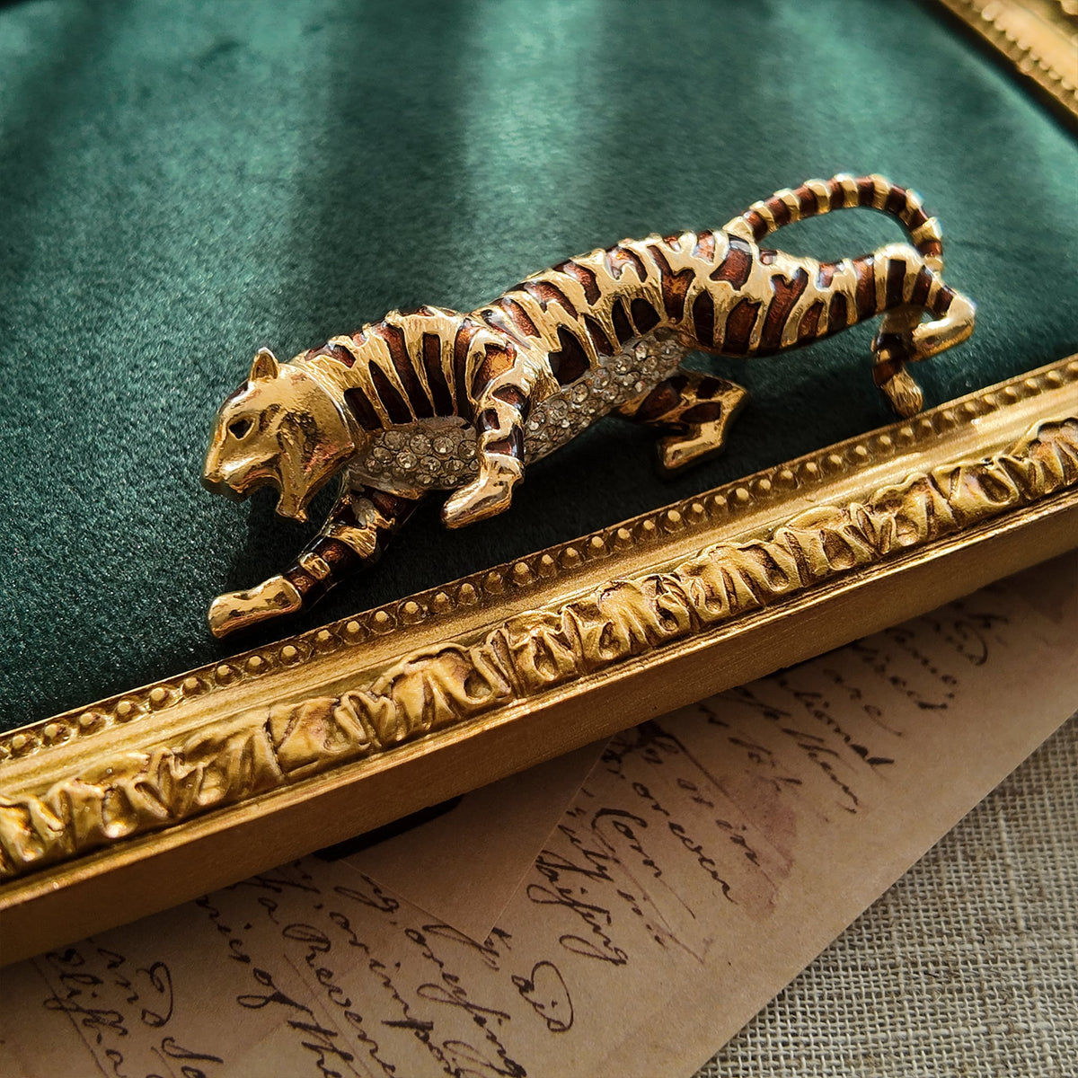 The "Jungle Queen" tiger brooch styled on a dark, moody background to emphasize its fierce, powerful aesthetic and its identity as a symbol of strength.