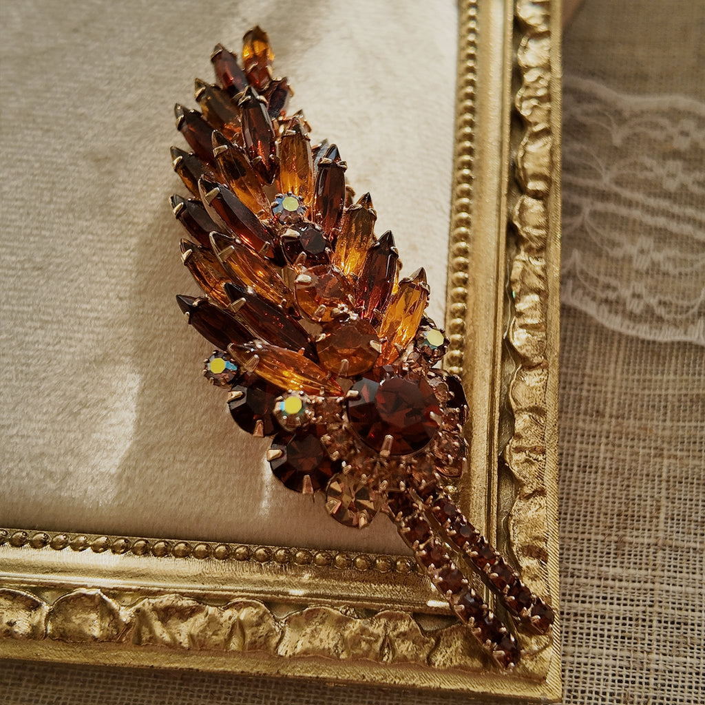 A macro shot detailing the unique, trapezoidal keystone-cut art glass and the fiery blue and purple flashes of the Aurora Borealis crystals on this collectible pin.