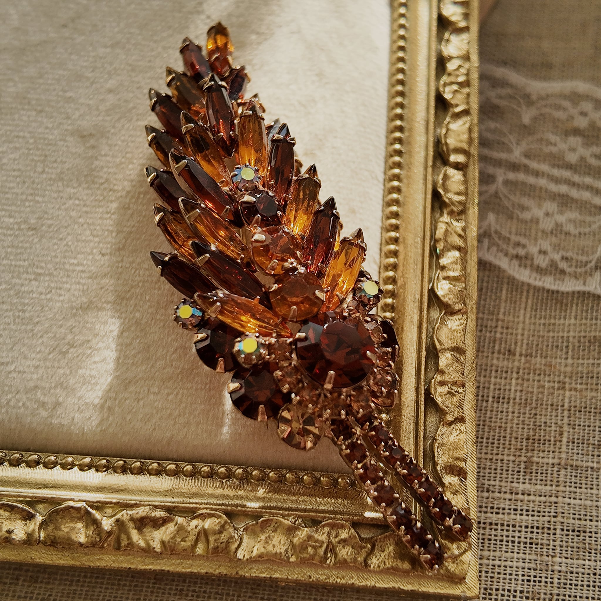 A macro shot detailing the unique, trapezoidal keystone-cut art glass and the fiery blue and purple flashes of the Aurora Borealis crystals on this collectible pin.