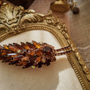 A macro shot detailing the unique, trapezoidal keystone-cut art glass and the fiery blue and purple flashes of the Aurora Borealis crystals on this collectible pin.