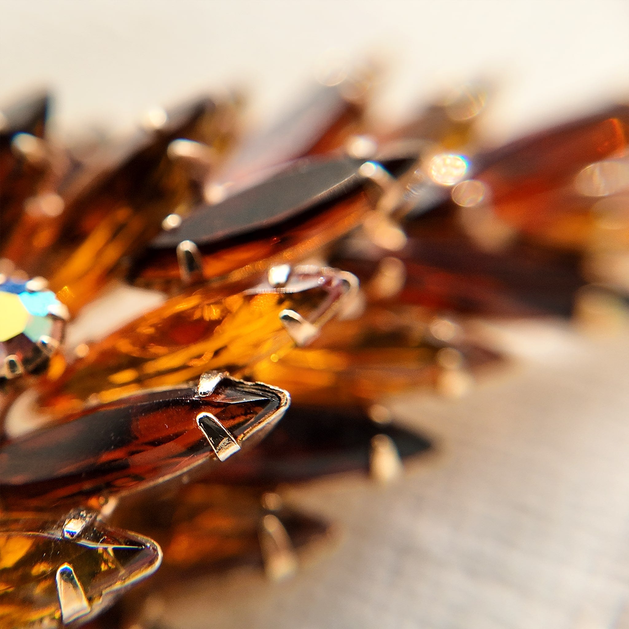 A macro shot detailing the unique, trapezoidal keystone-cut art glass and the fiery blue and purple flashes of the Aurora Borealis crystals on this collectible pin.