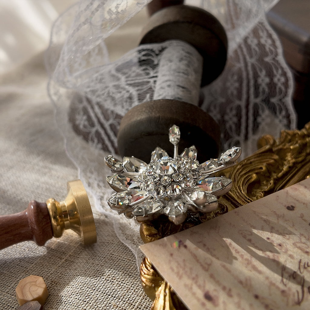An angled view of the crystal snowflake brooch, highlighting the masterful, three-dimensional layering of the hand-set rhinestones, a hallmark of Original by Robert.