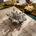 An angled view of the crystal snowflake brooch, highlighting the masterful, three-dimensional layering of the hand-set rhinestones, a hallmark of Original by Robert.