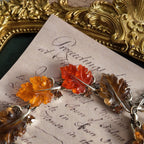 An angled view of the botanical necklace, highlighting the beautiful, semi-translucent quality of the hand-carved Lucite leaves that glow like candy.