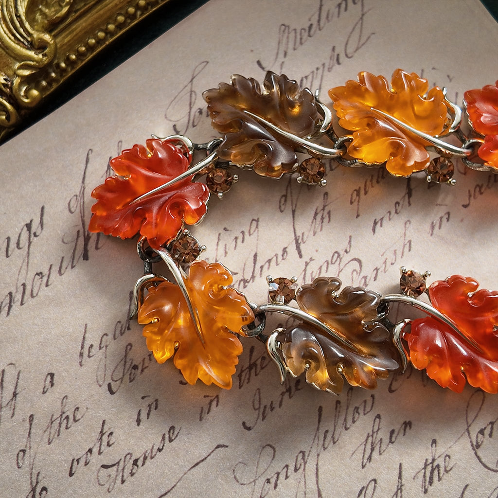An angled view of the botanical necklace, highlighting the beautiful, semi-translucent quality of the hand-carved Lucite leaves that glow like candy.