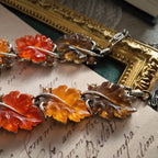 An angled view of the botanical necklace, highlighting the beautiful, semi-translucent quality of the hand-carved Lucite leaves that glow like candy.