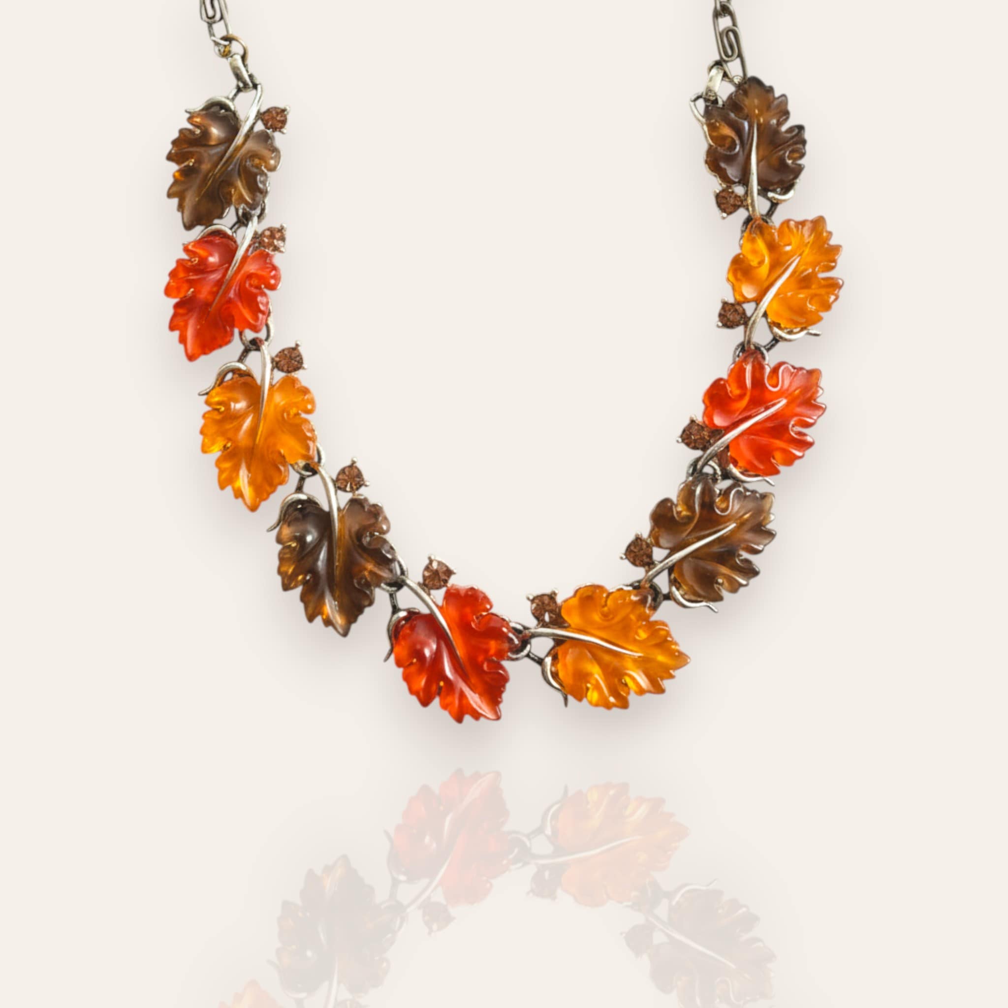 The "Sunshine Carrier," an iconic vintage Lisner statement necklace, featuring a cascade of carved Lucite leaves in vibrant orange, amber, and yellow hues.
