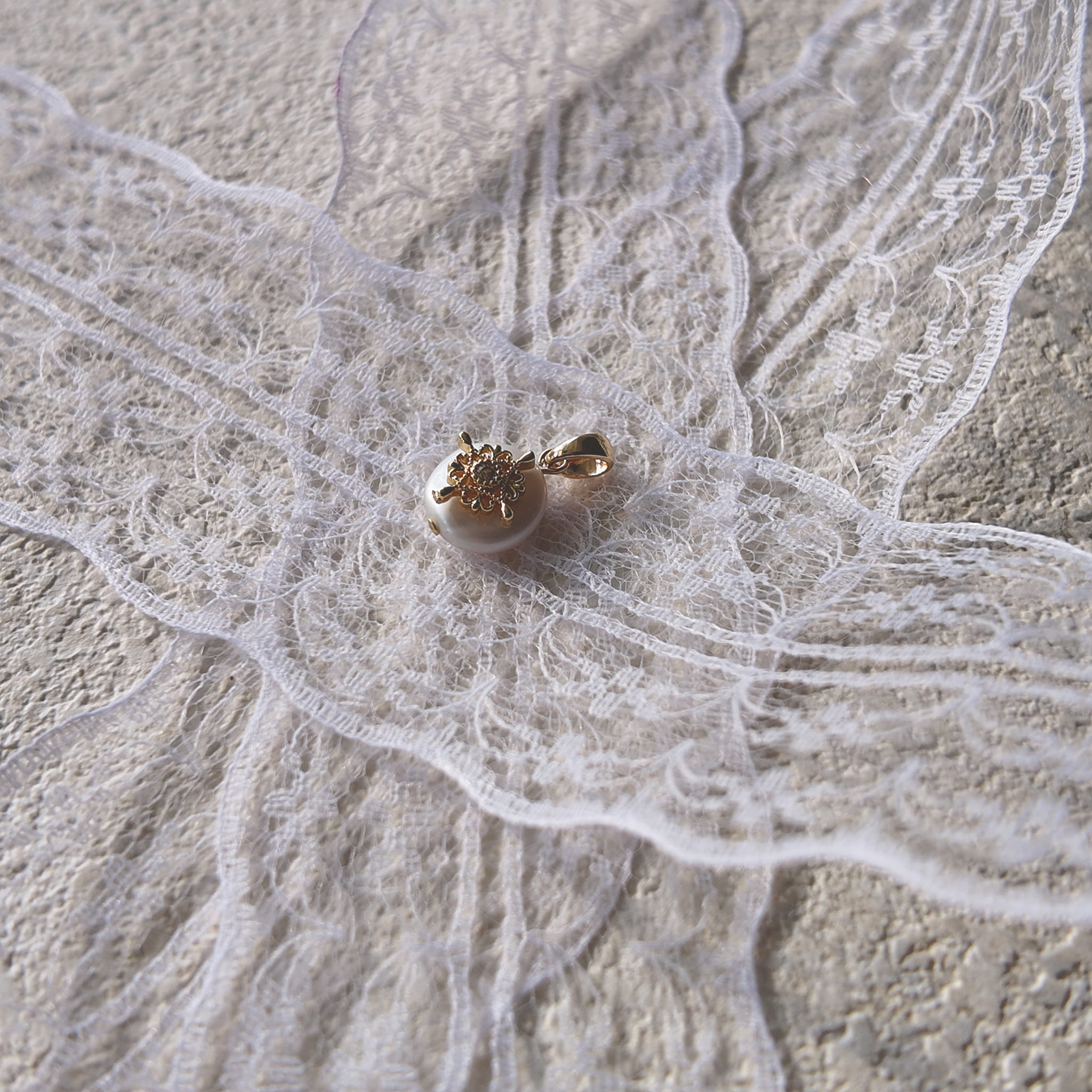 A macro shot detailing the soft, natural luster of the freshwater pearl and the tiny, star-like sparkle of the central cubic zirconia in the filigree.