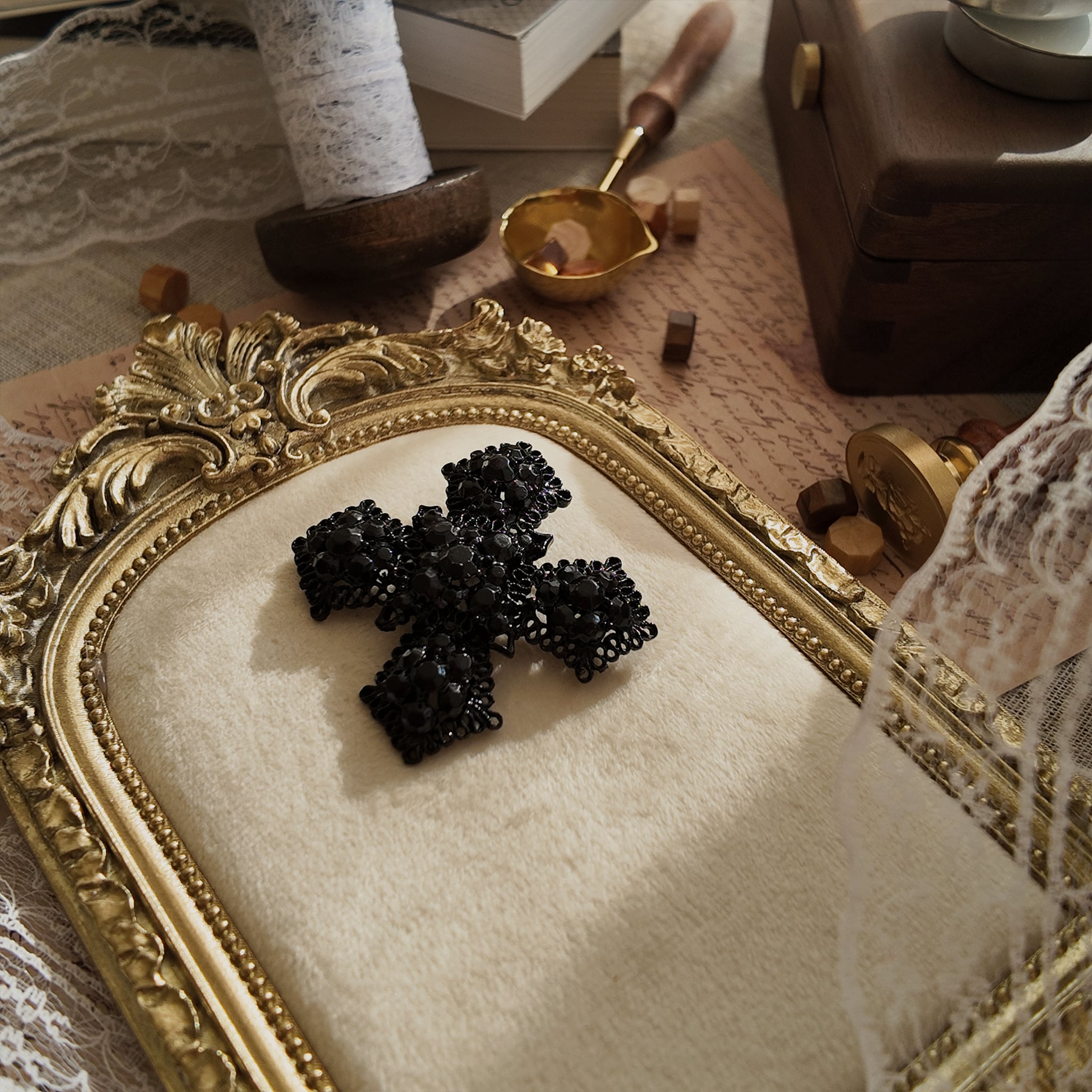 An angled view of "The Vampire Matriarch" brooch, highlighting the three-dimensional depth of the black-painted metal filigree and the deep-set crystals.