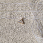 The "Siren's Farewell" mermaid tail charm worn on a fine gold chain, showcasing its delicate, feather-light size and its ethereal, minimalist aesthetic.