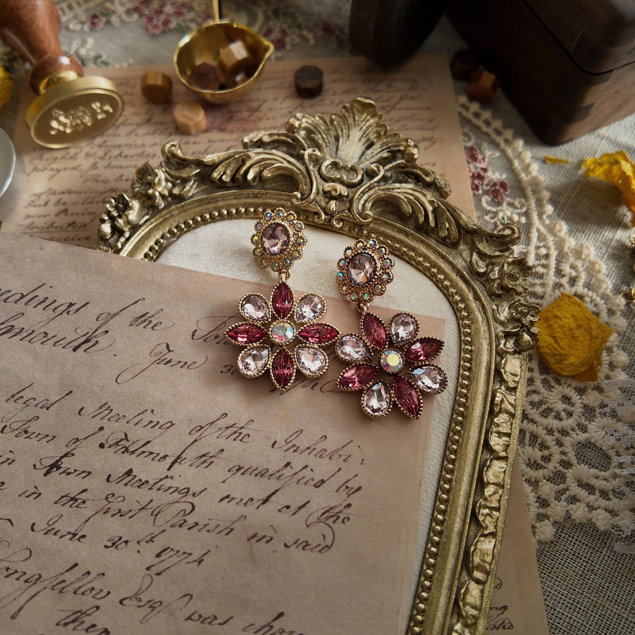An angled view of the pink crystal earrings, highlighting the beautiful symphony of rose, magenta, and iridescent faux opal stones in a gold-plated setting.