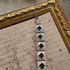 The "Flapper Architect," a vintage Napier Art Deco style panel bracelet featuring a geometric pattern of silver-tone links with black and clear rhinestones. 