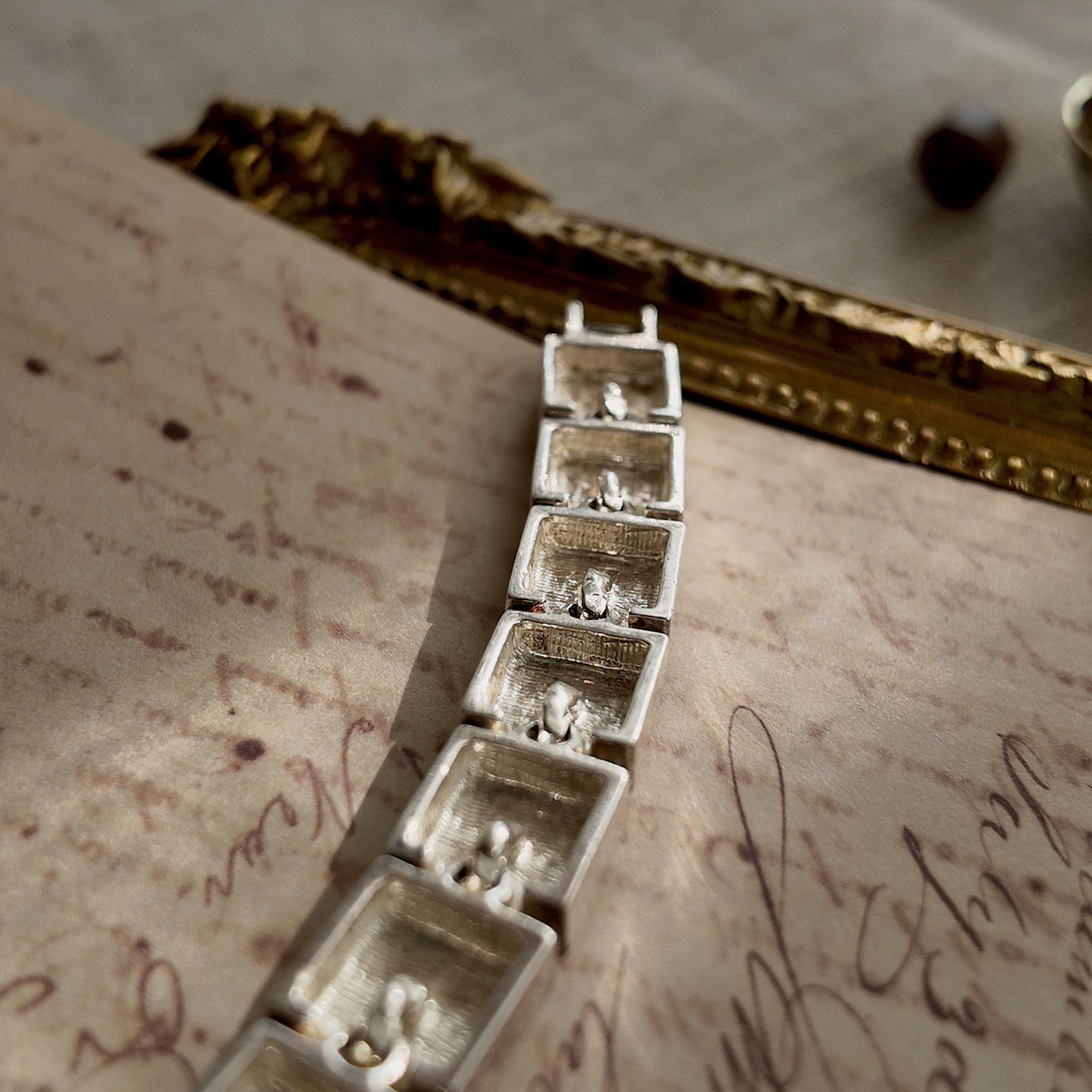 A close-up of the authentic "Napier" signature on the clasp of the vintage silver-plated Art Deco style panel bracelet.