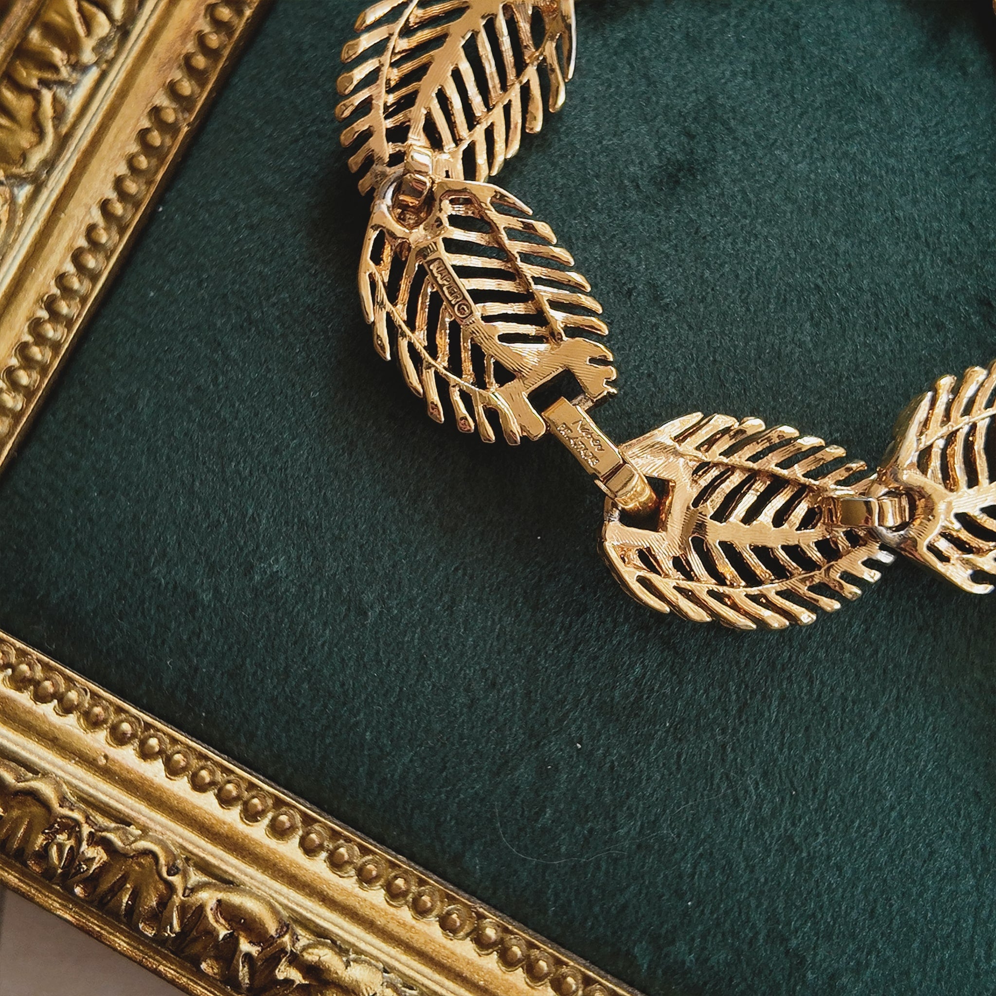 A macro shot of the necklace clasp, clearly showing the authentic "NAPIER" signature and the historically significant "PAT. 4,774,743" mark.