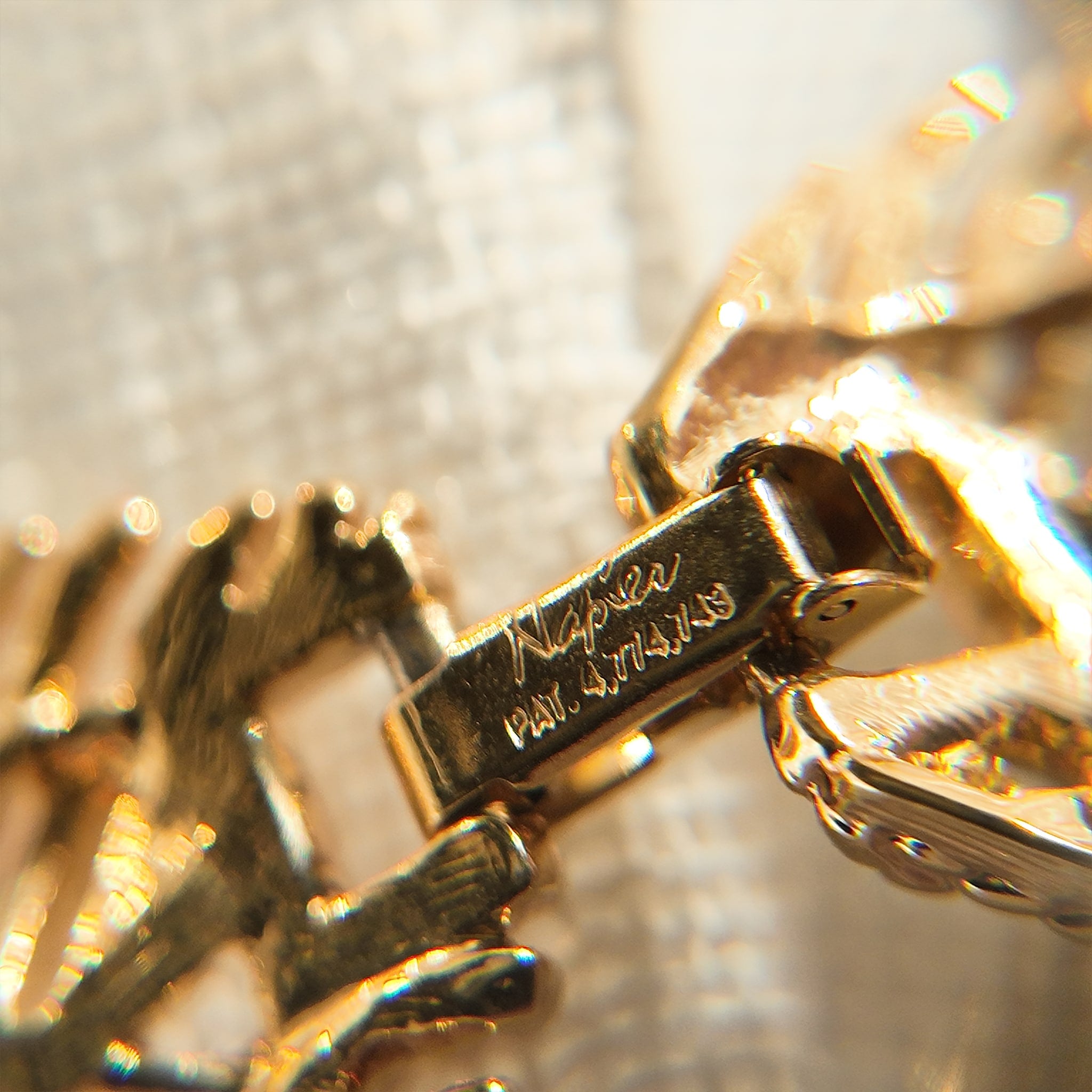 A macro shot of the necklace clasp, clearly showing the authentic "NAPIER" signature and the historically significant "PAT. 4,774,743" mark.