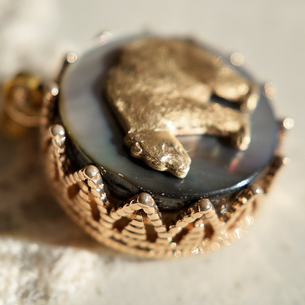 A macro shot detailing the shifting, rainbow-like nacre of the Black Mother-of-Pearl, which creates the magical, star-like quality of this constellation jewelry piece.