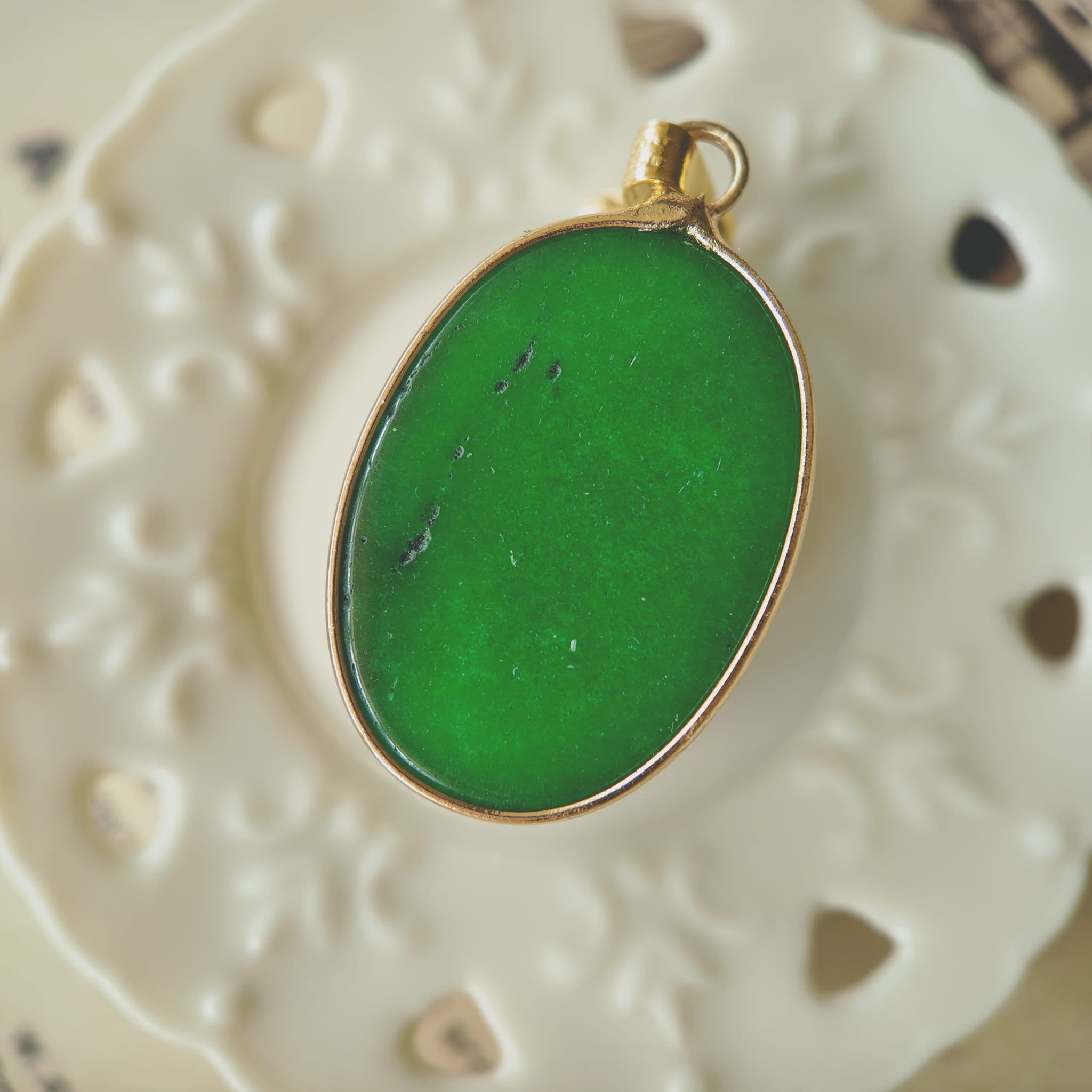 Texture detail of the natural green jade, showing its rich, dark emerald tone, opaque quality, and polished surface.