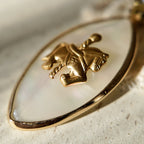 A macro shot detailing the soft, blurry, rainbow-like nacre of the Mother-of-Pearl, which creates the magical, dreamlike quality of this coquette jewelry piece.