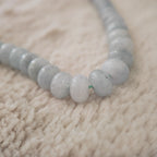 A macro shot detailing the beautiful, natural white "floating flowers" (inclusions) within the polished, pale blue stones, a sign of their authentic, natural origin.