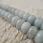 A macro shot detailing the beautiful, natural white "floating flowers" (inclusions) within the polished, pale blue stones, a sign of their authentic, natural origin.