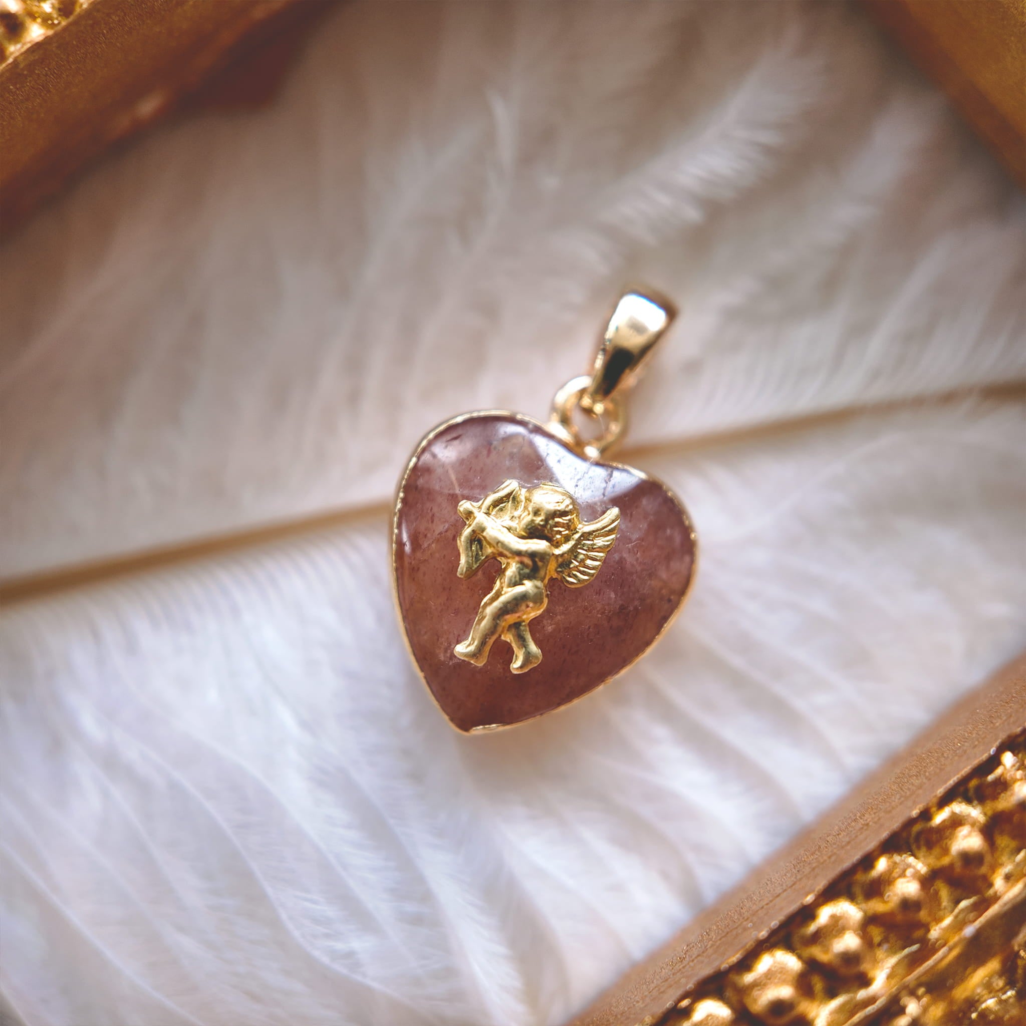 A macro shot detailing the visible internal red inclusions or "seeds" within the Natural Strawberry Quartz, which give the stone its characteristic "strawberry" look.