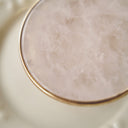 Texture detail of natural white quartz disc, showcasing its semi-translucence and natural inclusions that catch light like sunbeams through clouds.