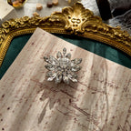 The "A Flawless Winter Bloom," a vintage Original by Robert snowflake brooch, featuring intricate layers of brilliant, diamond-like Austrian crystals in a silver-tone setting.