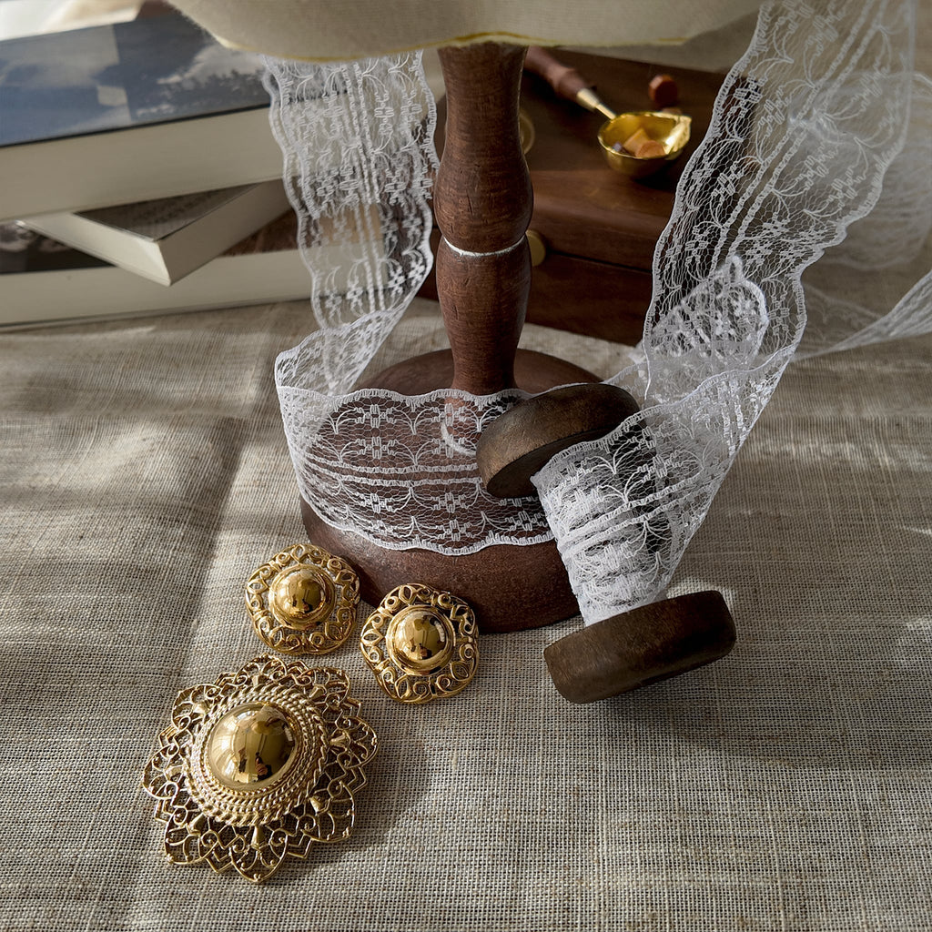 The Trifari hat brooch and earring set styled with a classic little black dress to emphasize its "playful elegance" and its versatility as a perfect finishing touch.